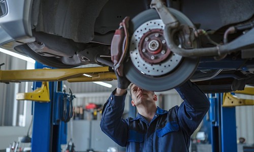 Technician inspecting brakes-Auto Mechanical Repairs